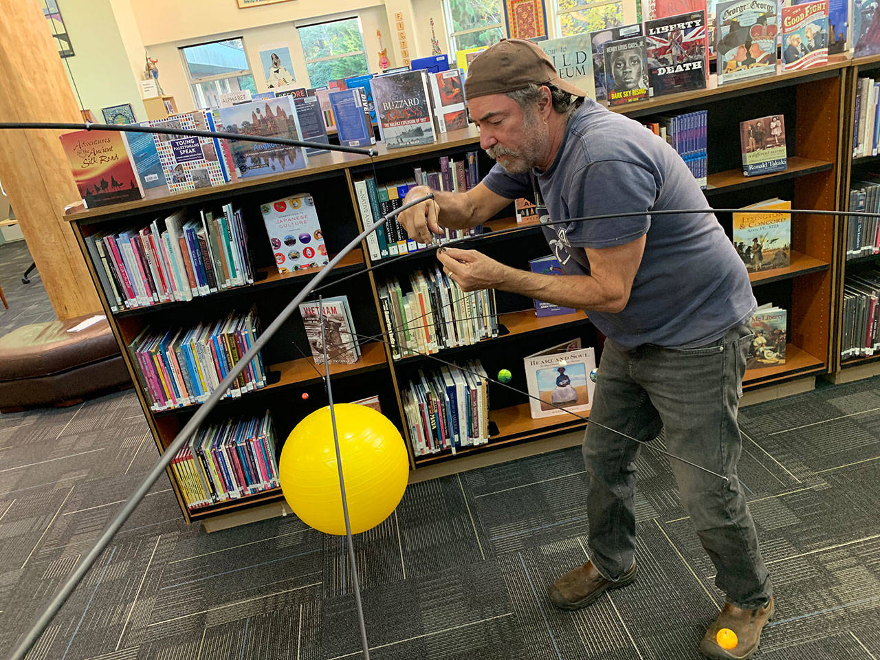 Scott Durkee with the mobile he created for the McMurray Middle School library (Kevin Opsahl/Staff Photo).