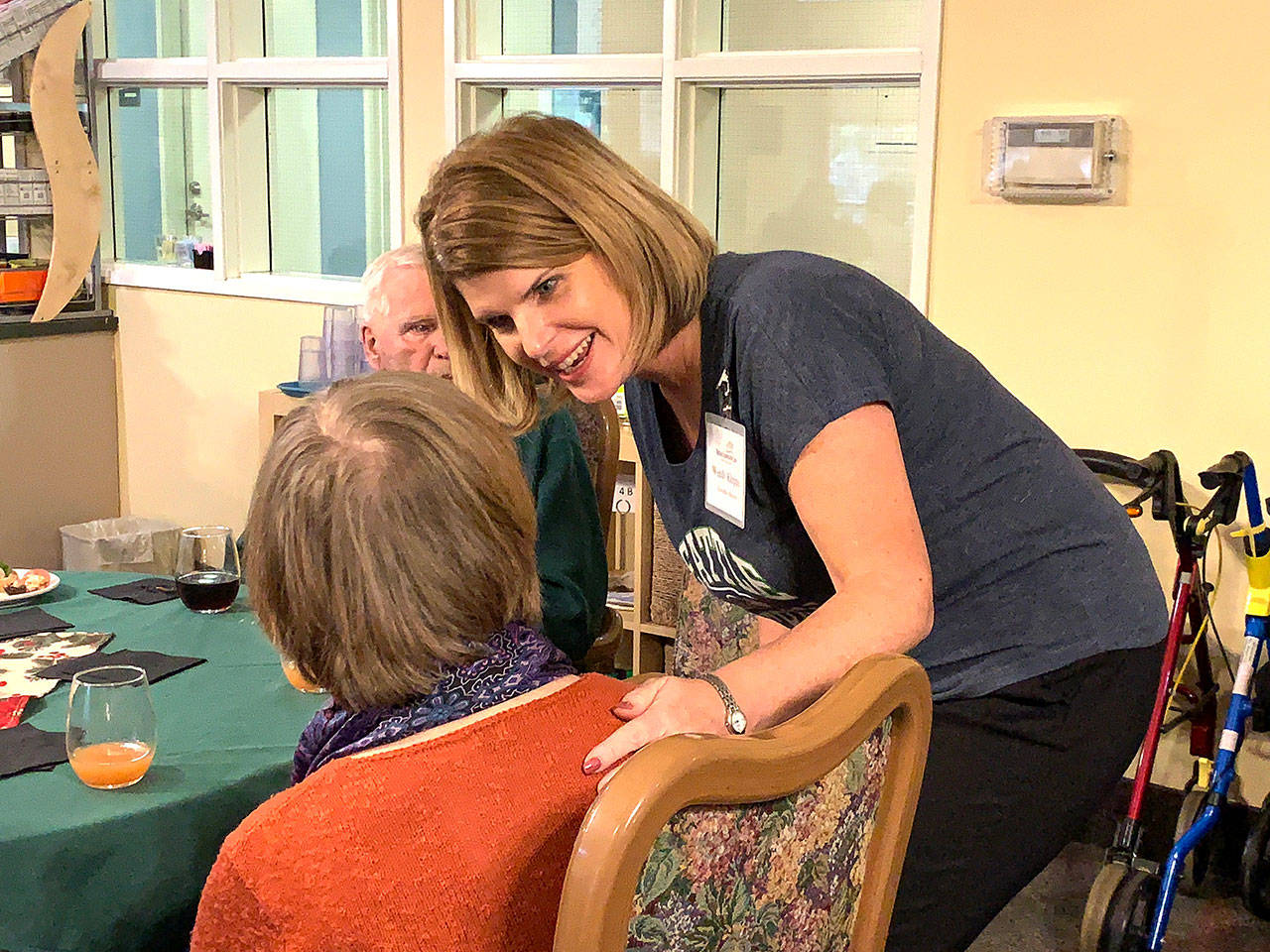 Wendy Kleppe, the new executive director of Vashon Community Care, greets a resident during a reception at the senior living community on Dec. 6. (Kevin Opsahl/Staff Photo)