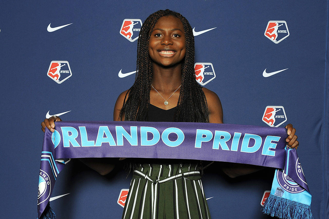 Abi Kim, who grew up on Vashon and attended McMurray Middle School, poses with an Orlando Pride banner at the National Womens Soccer League draft in Baltimore, Md. on Thursday, Jan. 16 (ISI Photos)