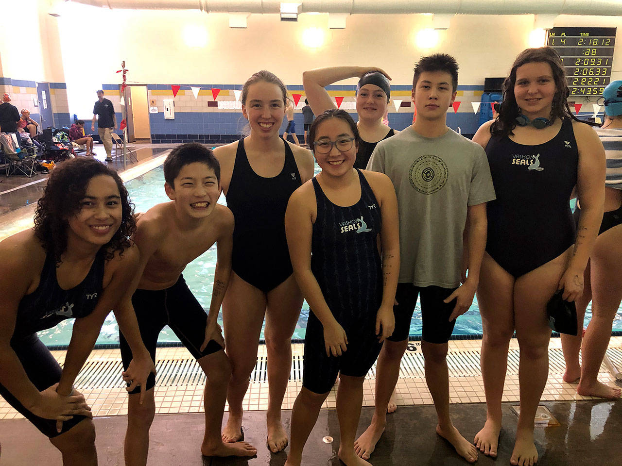 (From left to right) Aliya Ricks, Jamie Choo, Ellie Jackson, Saffron Hinz, Nola Watson, Ethan Choo and Haley Hopper pose for a portrait during the Pacific Northwest Swimming Winter Challenge series at Mount Tahoma High School in Tacoma (Karl Stetson Photo).