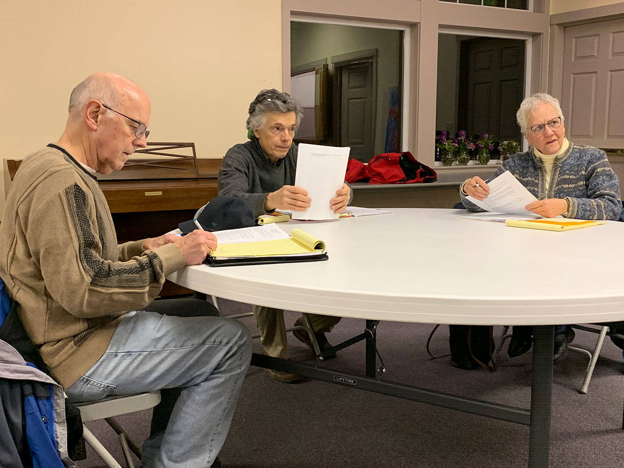 Vashon Health Care District commissioners (left to right) Eric Pryne, Don Wolczko and Wendy Noble talk to attendees of the meeting moments before it convenes on Feb. 5. (Kevin Opsahl/Staff Photo)