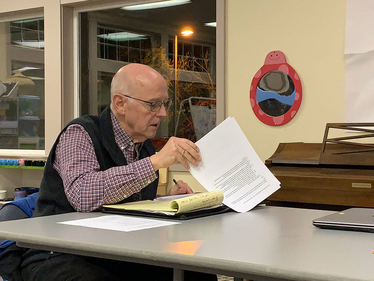 Vashon Health Care District commissioner Eric Pryne looks over his notes during a meeting at Vashon Presbyterian Church on Wednesday, Feb. 19. (Kevin Opsahl/Staff Photo)