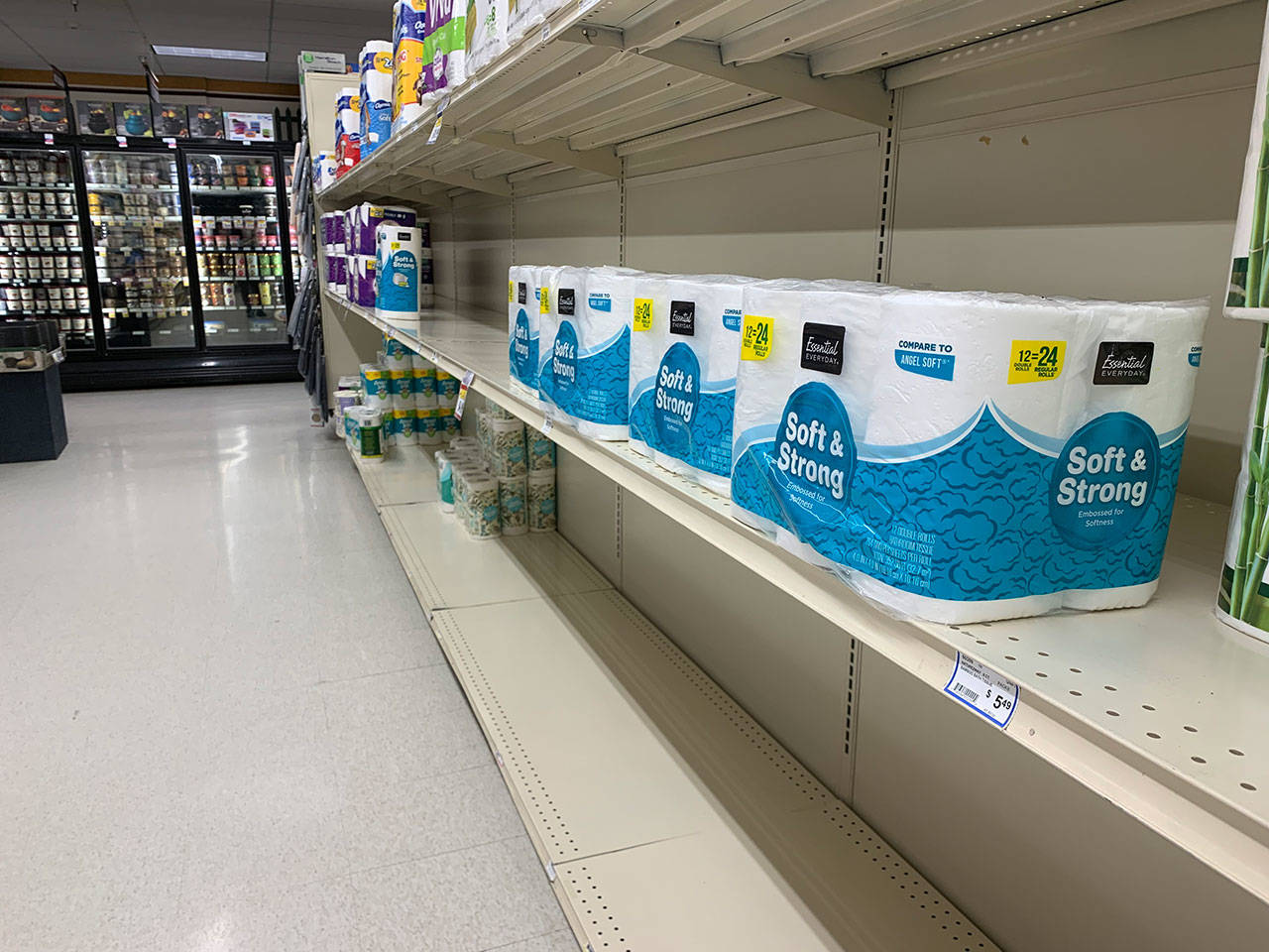 Empty or almost bare shelves in the toilet paper and towel aisle of Vashon Thriftway are seen on Monday night. (Kevin Opsahl/Staff Photo)