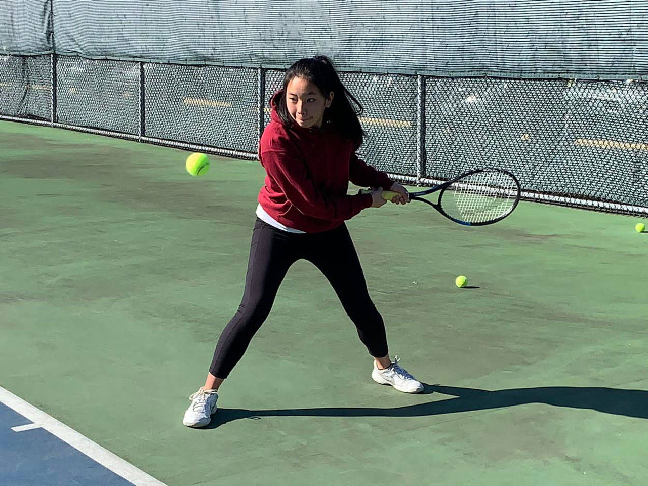 Lia Crawford, captain of the Vashon Island High School girls tennis team, practices her swing on Monday, March 9, at the school. (Kevin Opsahl/Staff Photo)