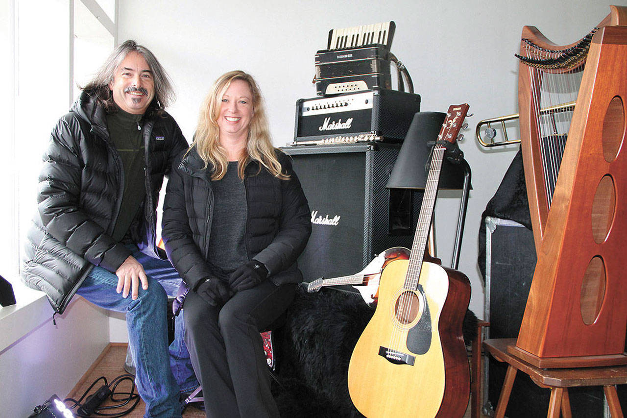 In this Beachcomber file photo from 2018, Pete Welch and Allison Shirk, of Vashon Events, smile for the camera in front of some of the many instruments that make up Vashon Events’ free lending library of musical instruments and gear (Susan Riemer Photo).