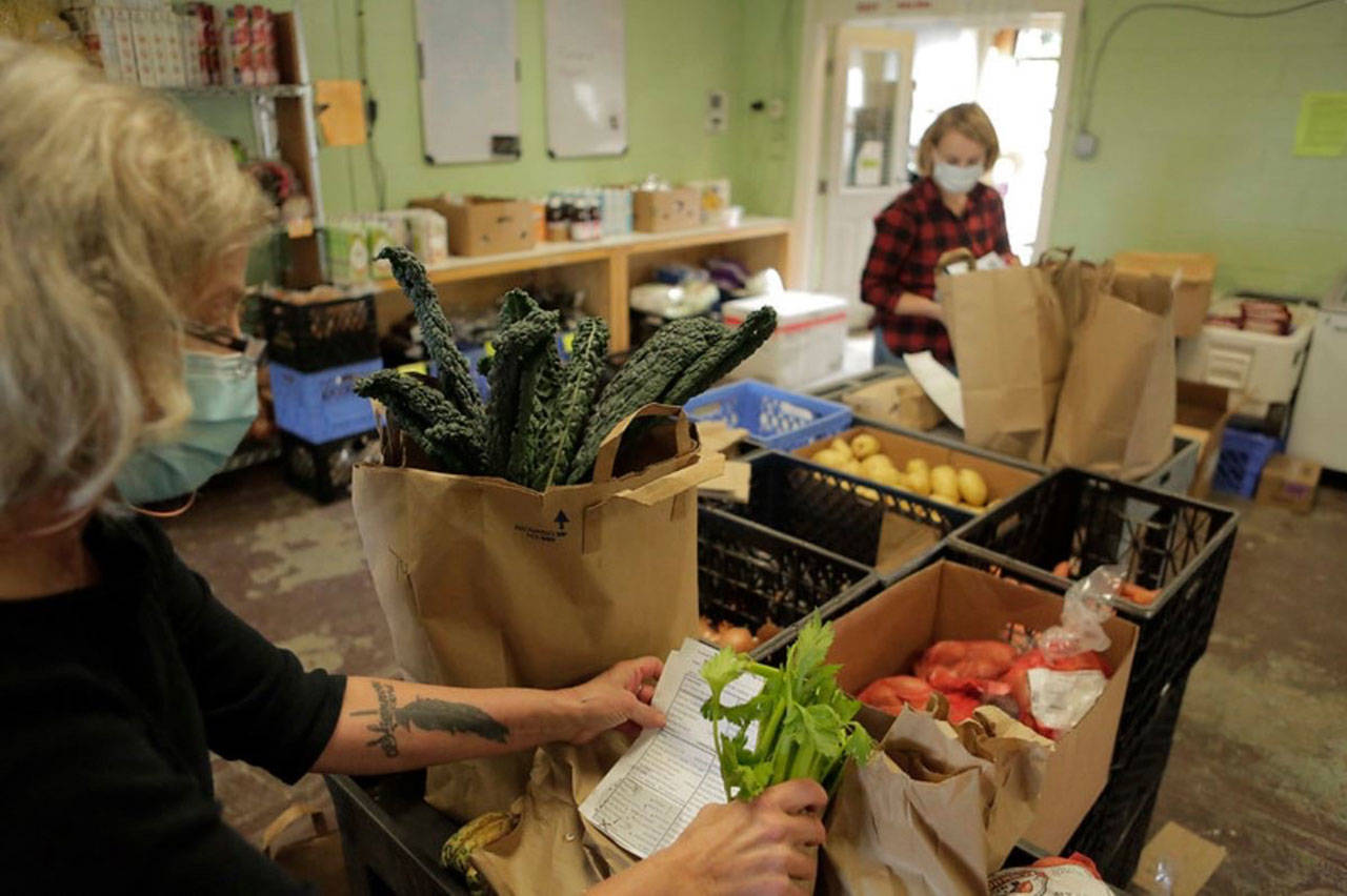 Volunteers at Vashon Food Bank pack customized grocery orders for home delivery. The food bank has adapted with COVID-19 to feed the community (Photo Courtesy Vashon Food Bank).