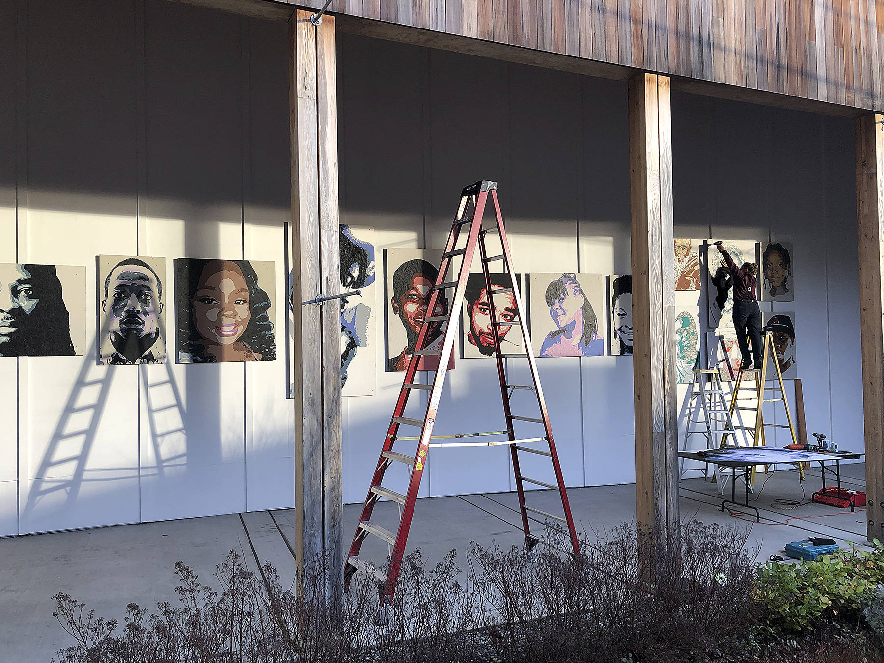 Local artist and exhibit designer Jessica DeWire helps puts the finishing touches on The Vashon Remembrance Project’s new installation at Vashon Center for the Arts (Tom Hughes Photo).