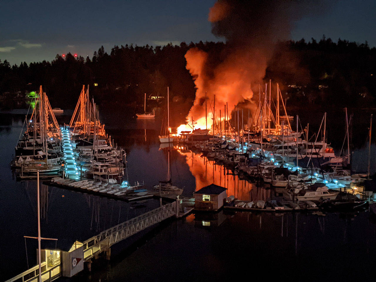 After an explosion shook Burton early Monday morning, two 40-foot fiberglass vessels caught fire and sunk. The cold weather made the Quartermaster Marina dock slippery for firefighters putting out the fire (Matt Wilson Photo).