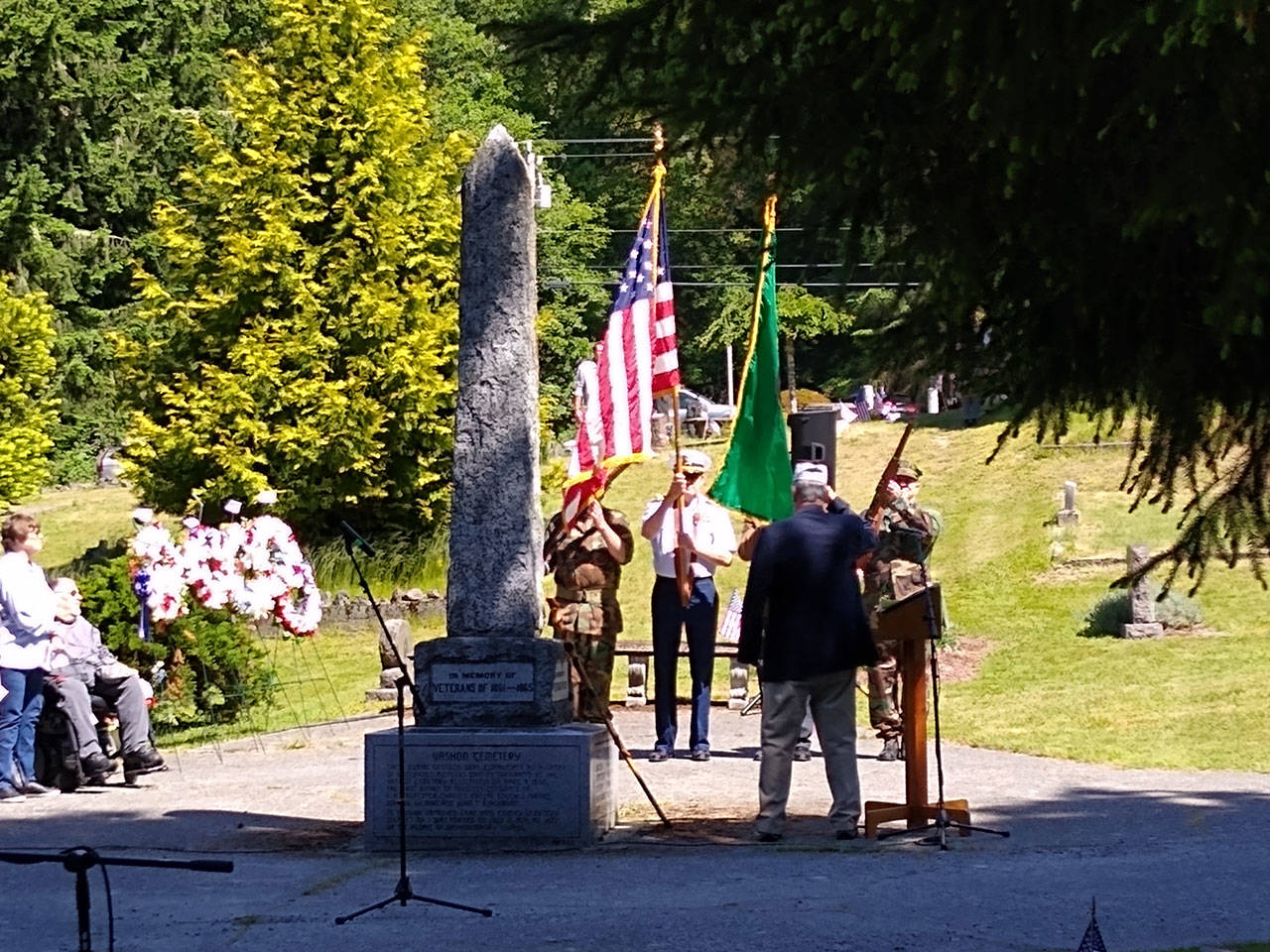 The War Memorial behind the day’s speakers at Vashon Cemetary has stood for a century, commemorating those who have died in conflicts dating back to 1861 (Paul Rowley Photo).