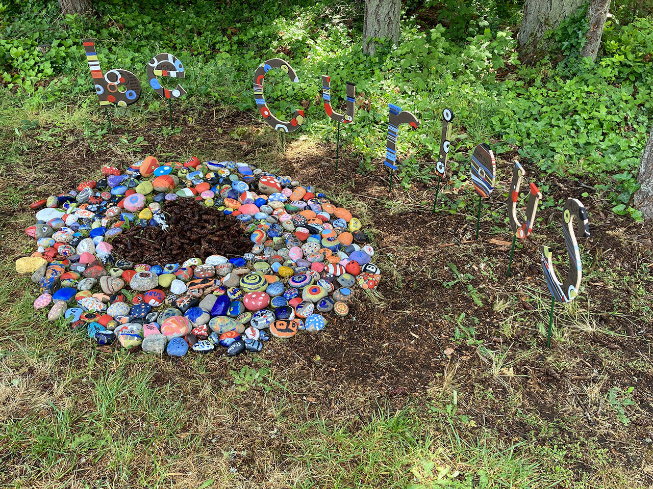 Guided by island artist Britt Freda, students installed painted rocks at the entrance to the school on Cemetery Road. A public unveiling of the exhibit, “BE CURIOUS: compassion and kindness rocks!” took place earlier this month (April M. Wilkinson Photo).