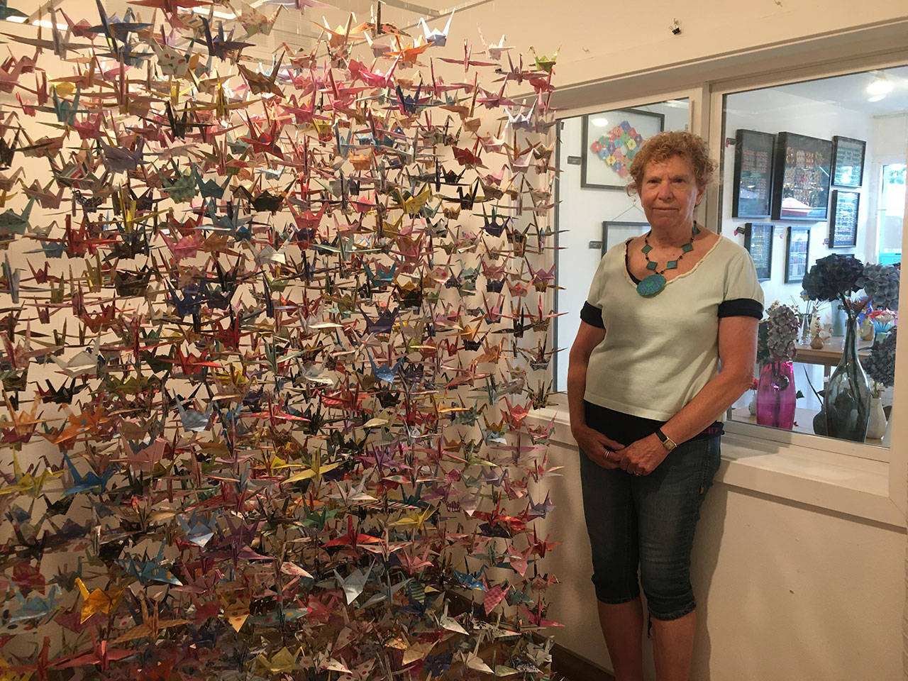 Alice Larson, origami artist and owner of Island Paper Chase, has painstakingly folded a paper crane for every life lost to COVID-19 in King County and created an artwork that displays them all. The gallery is located at 17635 Vashon Hwy. S.W. (Elizabeth Shepherd Photo).