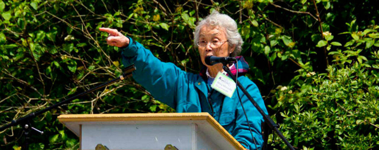 (Nick Anderson Photo) Mary Matsuda Gruenewald, speaking at the 2013 Washington Trust for Historic Preservation, “This Place Matters” rally outside the Mukai Farm and Garden, which had been fenced off by those who then controlled the property. In a passionate speech, Matsuda Gruenewald drew cheers from the audience with her upraised hand.