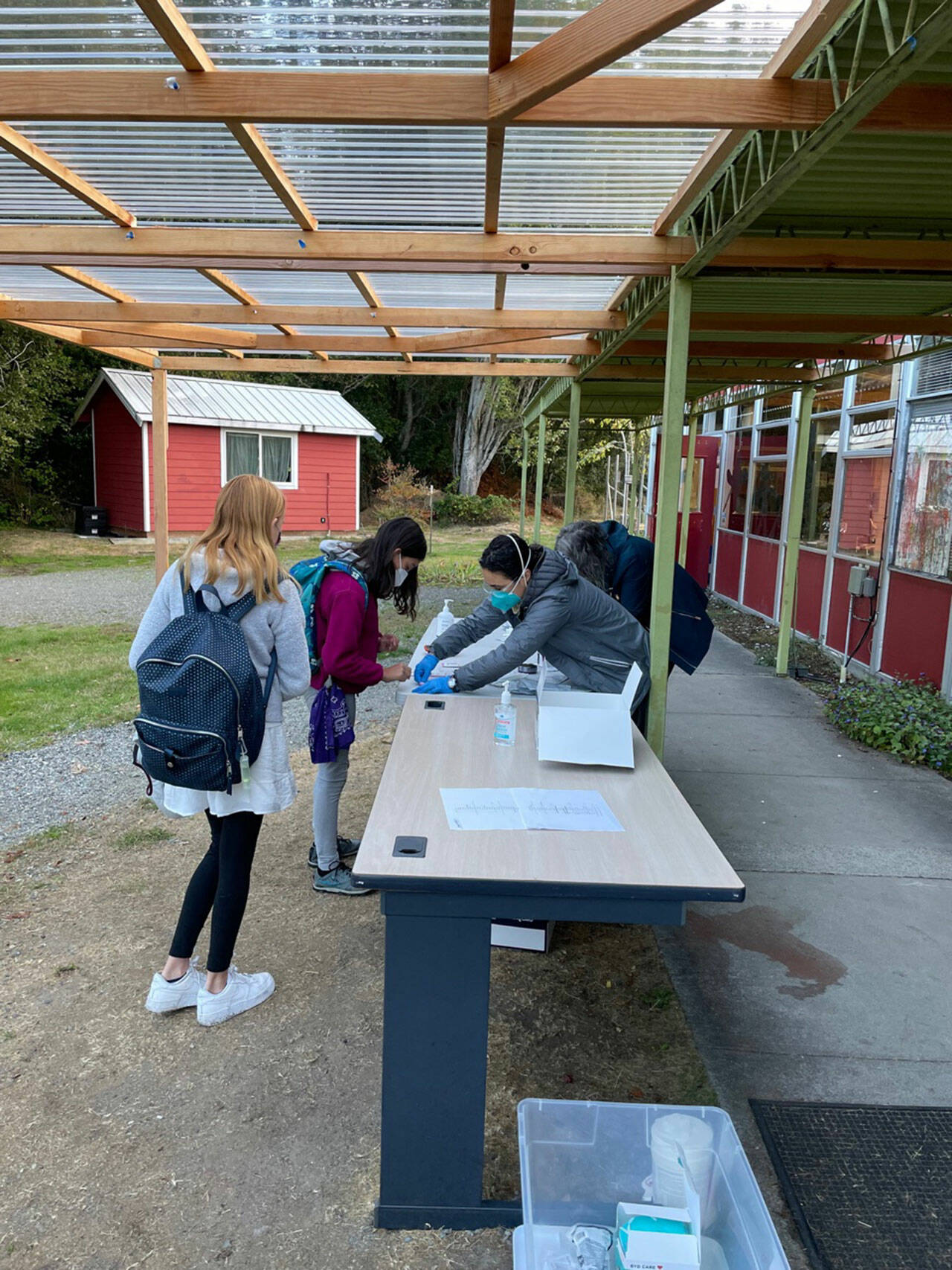 (Photo Courtesy Teri Rutledge) Students arriving to school and receiving rapid antigen tests.