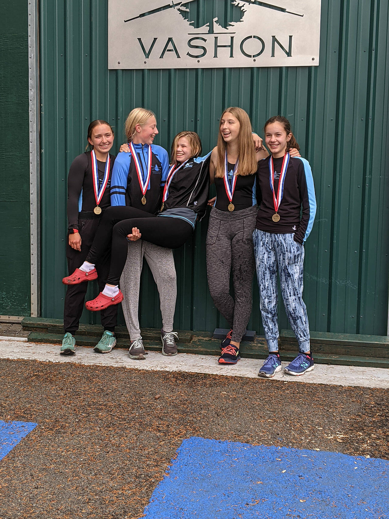 (Colby Atwood Photo) Novice girls quad celebrate their first place at Tail of the Lake. (Left to right) Laurel Calhoun, Julianna Steffens, Gray Foster (cox), Ava Webb and Selene Dalinis.
