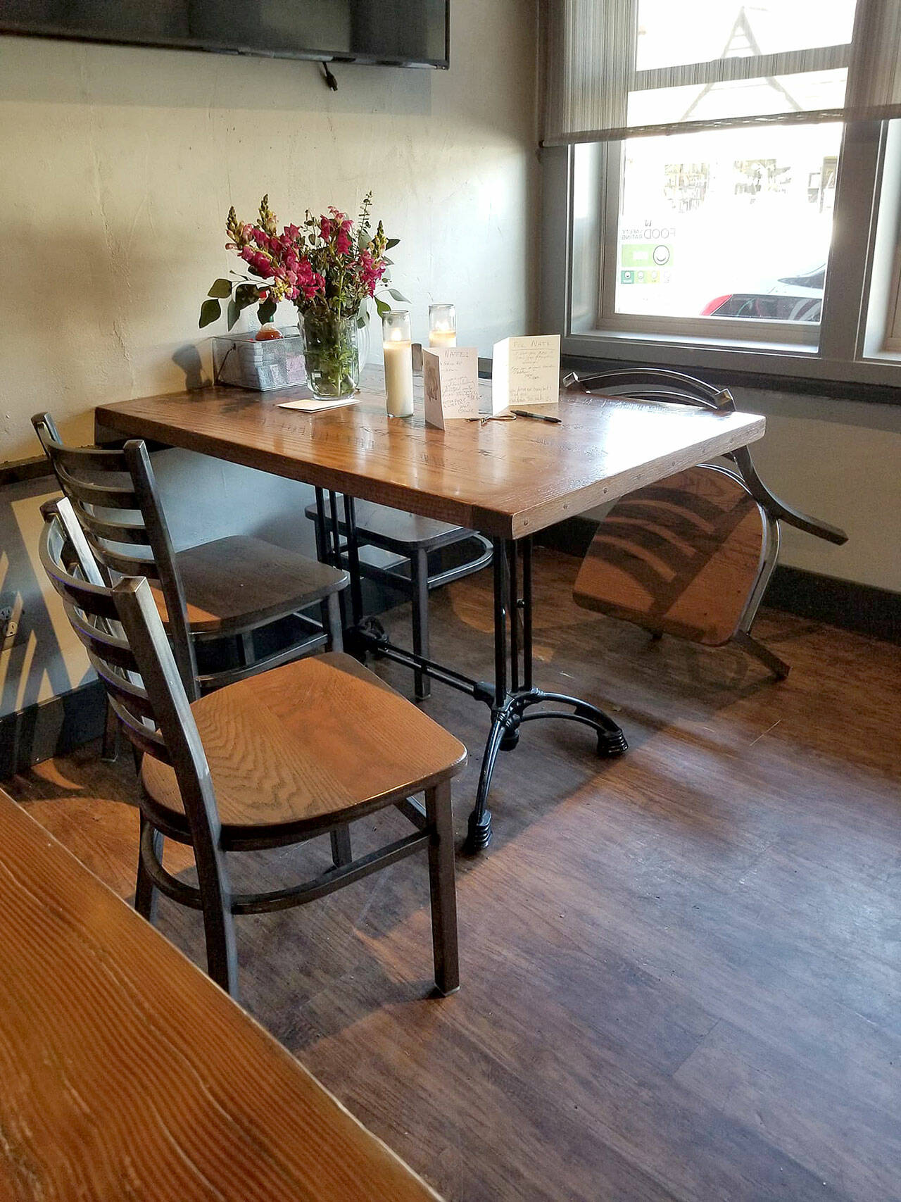 (Dorinda Kopp Photo) An empty chair, and a table set with cards and flowers, marked the death of a faithful customer, Nathan Dorn, Jr., at Sporty’s last week.