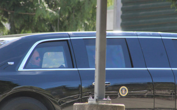 A man who appears to be President Joe Biden is seen in the back seat of a car in the president’s motorcade, departing the Green River College after the president’s speech. Photo by Alex Bruell/Sound Publishing