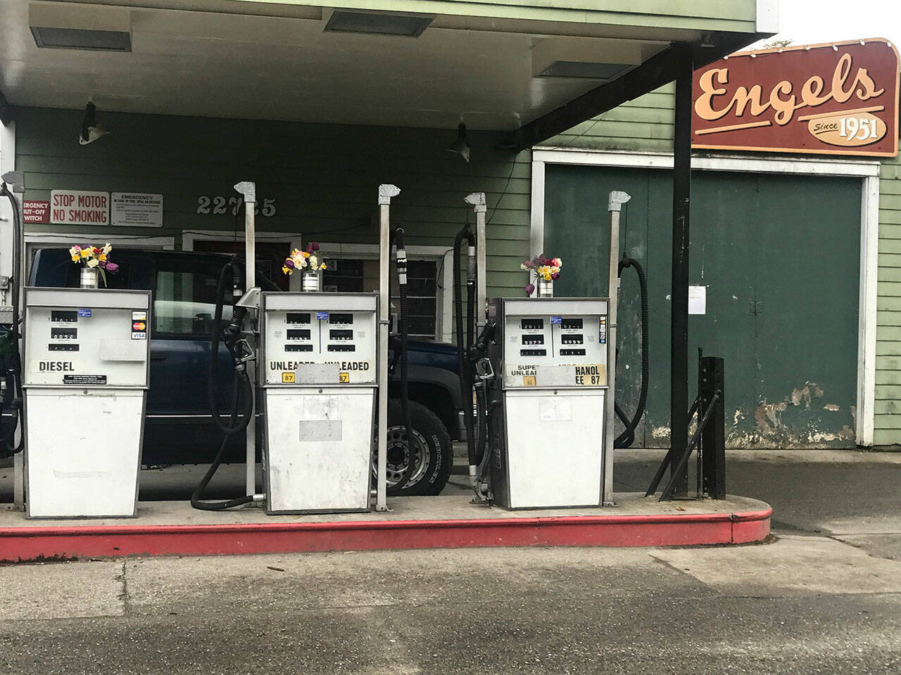 (Christine Carpenter Photo) Vases of flowers sit atop the gas pumps at Engels Repair & Towing.