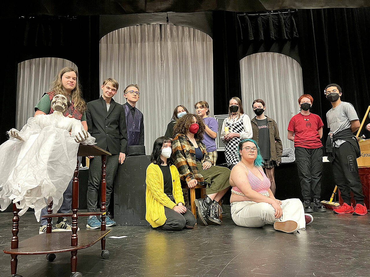 (Andy James Photo) The cast of A Spirited Manor, posing with the shows spooky mascot, Yulia (in lace dress) includes (back row, left to right) Japhy Tsaitsenhoven, Bishop Townsend, Nathan Campbell, Isaac Huff, Chloe Bay, Harper Hobson, El Otto, Chris Wechkin, Richard Barrett-Wood, and (front row, left to right) Phoebe Ray, Raena Joyce, Ari Officer. Not pictured: Ian Ingalls.