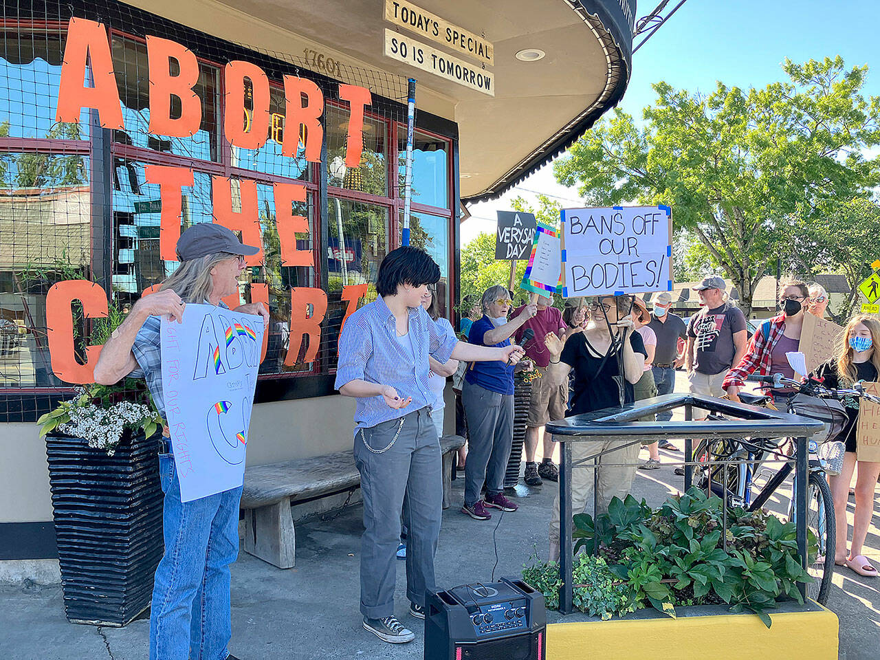 Islander Max Rulff hands the microphone back to Suzanne Greenberg, a member of Indivisible Vashon, after speaking to those who gathered on Friday to protest the U.S. Supreme Court’s decision to overturn Roe v. Wade. (Elizabeth Shepherd Photo)