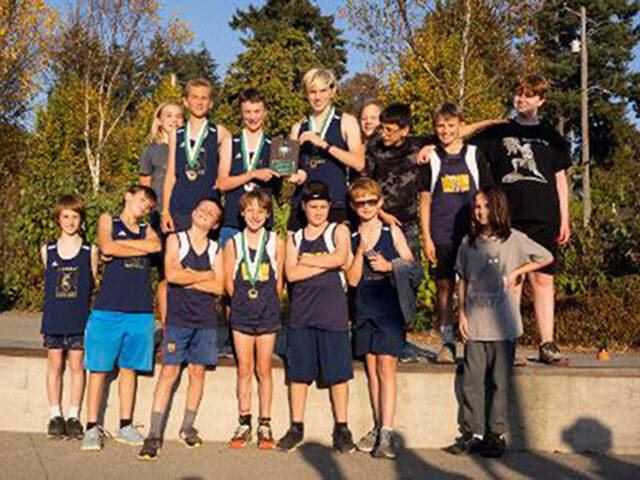 The McMurray boys’ track team savors the moment after they received their plaque for winning the League Championship on October 18, at Titlow Park in Tacoma (Courtesy Photo).