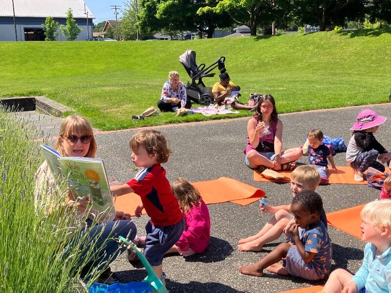 Children’s librarian Amelia Lincoln Ecevedo led a lively outdoor story hour at Ober Park, timed to coincide with Vashon Food Bank’s distribution of lunches (Elizabeth Shepherd Photo).