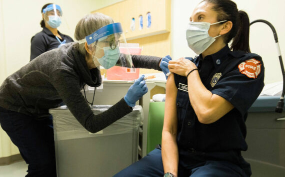 Public Health – Seattle & King County staff administering COVID-19 vaccine to a local emergency responder. COURTESY PHOTO, Public Health-Seattle & King County