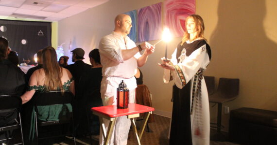 High Priest Kalu and High Preistess Syleena “Call The Corners,” a small ritual where a candle is lit at each direction of the Earth as the elements of each direction is called upon. Here they call on the guardian of the watchtower of the South, represented by red which symbolizes fire. Photo by Bailey Jo Josie/Sound Publishing.