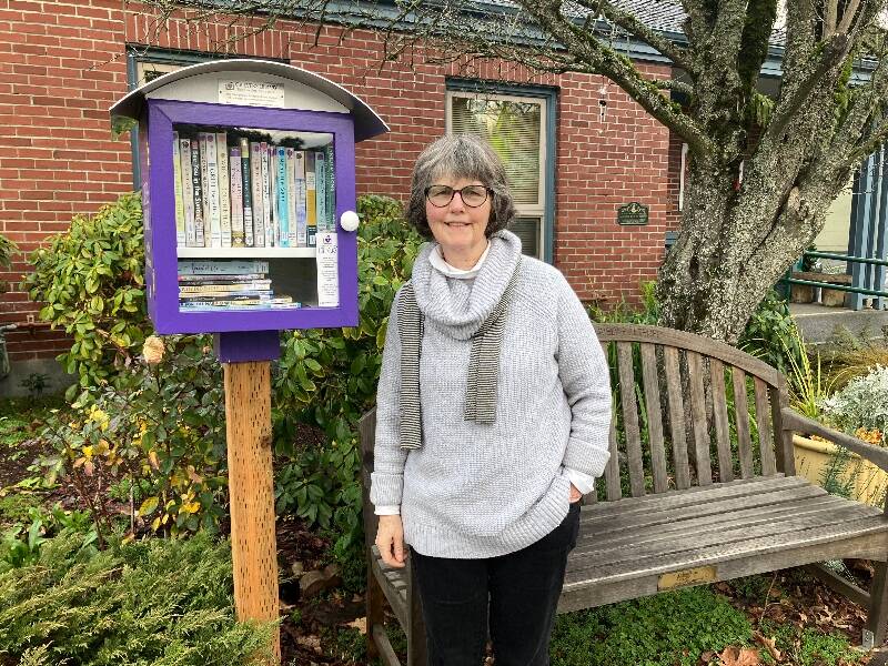 Pamela Belyea, the project coordinator for Griever’s Library, at the organization’s little library in front of Vashon’s Senior Center (Elizabeth Shepherd Photo).