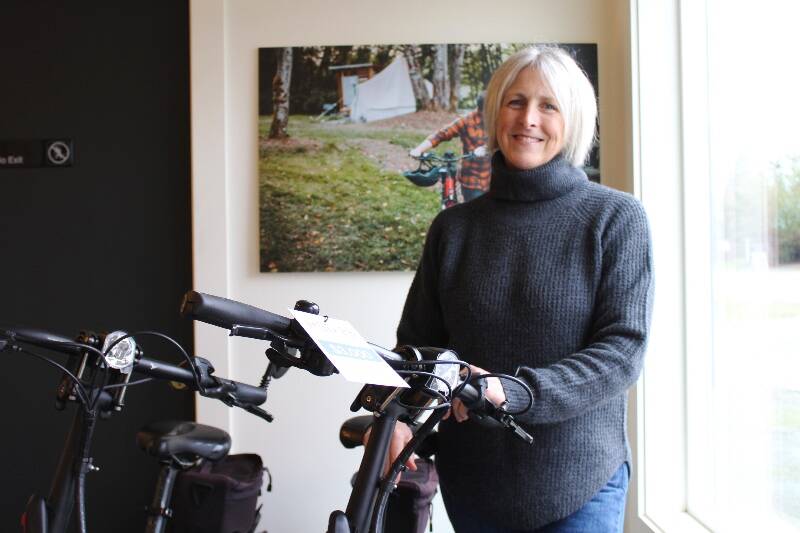 Vashon Adventures co-owner Erin Kieper stands next to the last of the company’s e-bikes at their in-town location. The bikes are all being sold as the business leaves behind the bike rental element of their operation (Alex Bruell Photo).