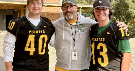 From left, Tallis Sullivan, football coach Brian Banducci and Memphis Cress stand outside Vashon High School before practice. (Aspen Anderson Photo)