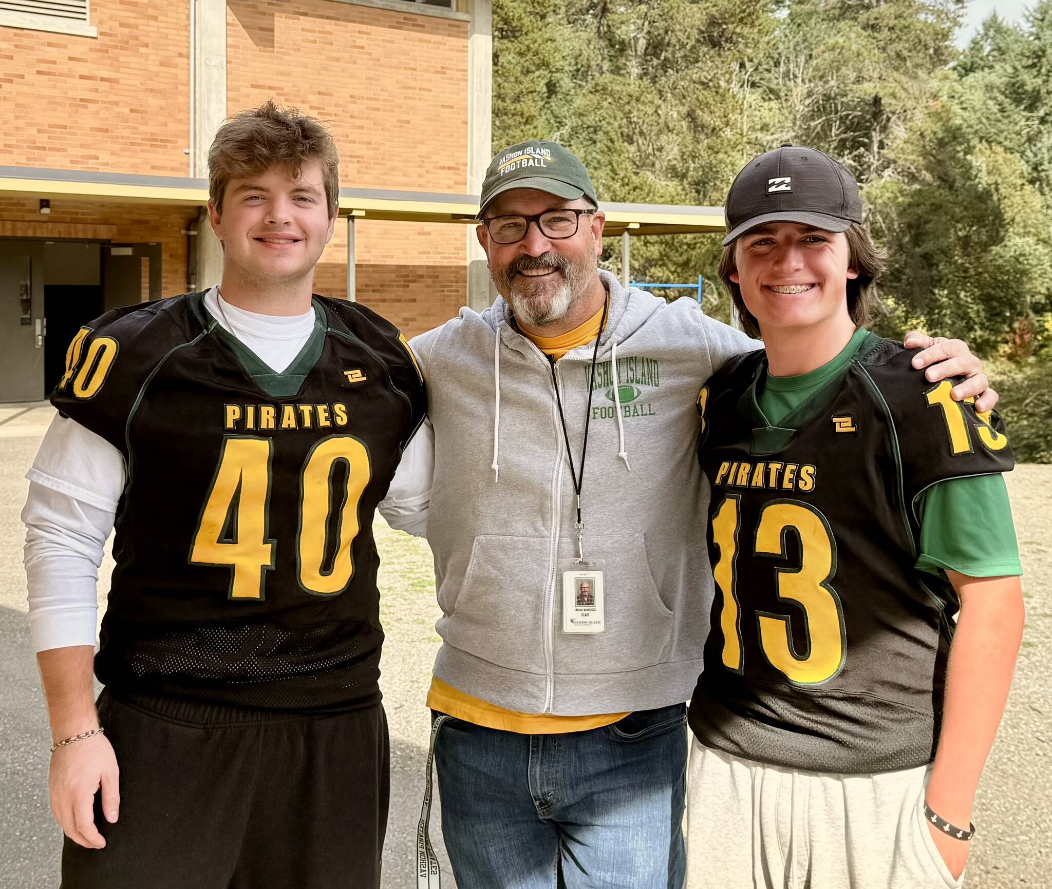 From left, Tallis Sullivan, football coach Brian Banducci and Memphis Cress stand outside Vashon High School before practice. (Aspen Anderson Photo)