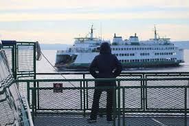 \A passenger on the Triangle route watches as another ferry passes on the way between Vashon and West Seattle. (Alex Bruell Photo)