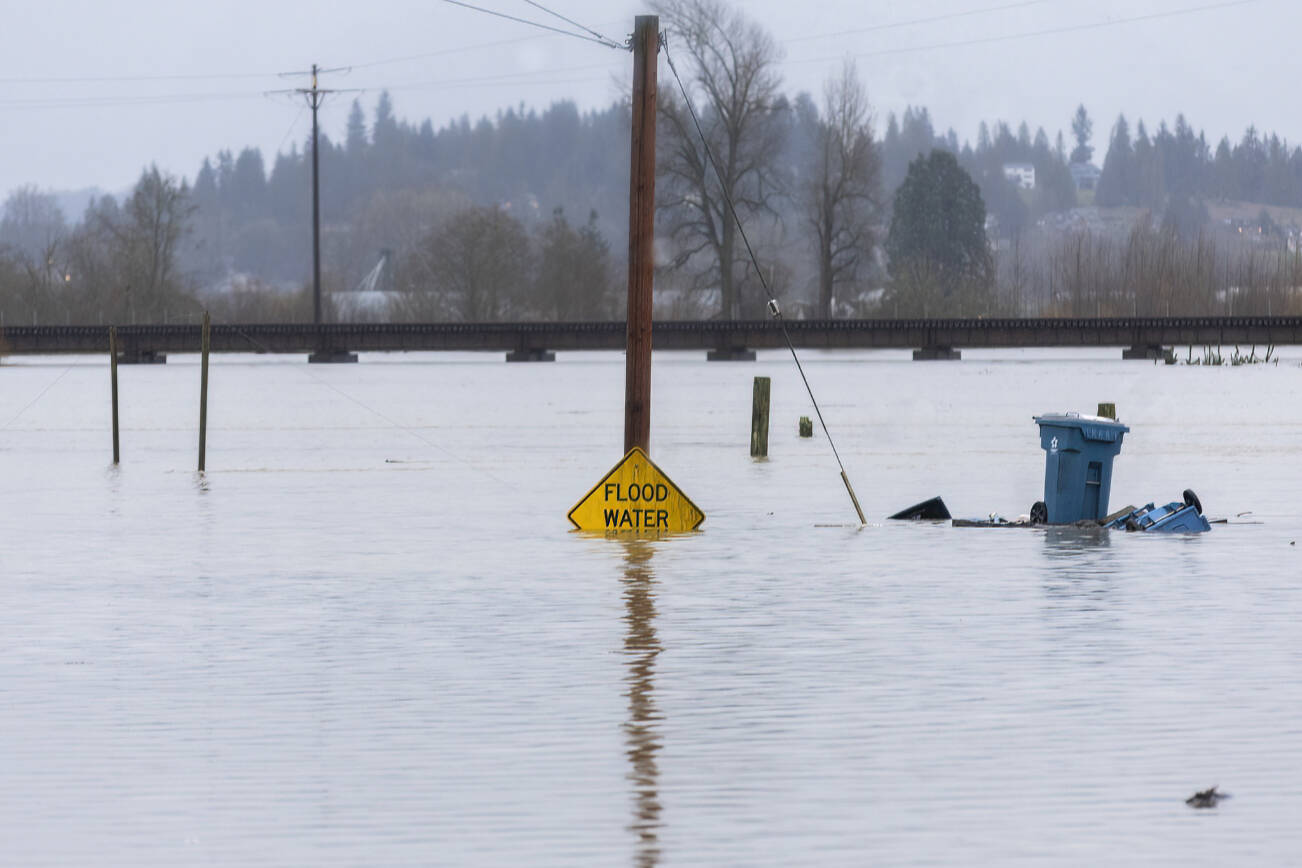 Floodwater from the Snohomish River partially covers a flood water sign on Thursday, Dec. 11, 2025 in Snohomish, Washington. (Sound Publishing photo)