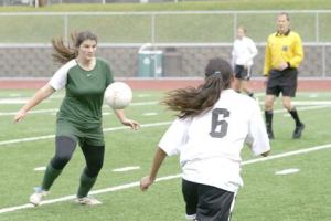 Midfielder Anna Jones sends the ball past Seattle Christian defender Kimberly Howard.