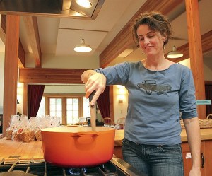 Hedy Anderson makes caramel last week at the Cohousing Common House. This week she has moved her operation into the former Little House building
