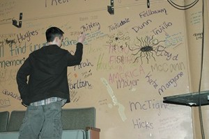 Zach Oriel adds to a colorful wall in the theater.
