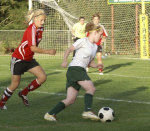 Teal Sigler maneuvers around an Orting defender for a shot.