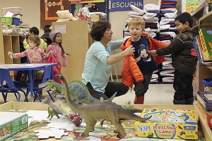 Mi Escuelita assistant teacher Lilia Longworth helps Harold Little with his jacket