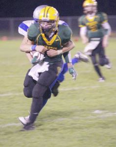 Peter Evans fights for every inch of yardage as a Chimacum tackler hangs on.