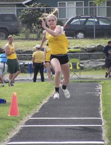 Kat Andrus makes her first-place triple jump at the league championships.