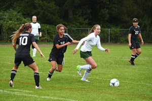 Senior Llira McEachern beats her opponents to the ball in a tough game against Seattle Christian on Friday.