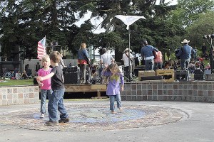 Children play during an outdoor concert last summer.