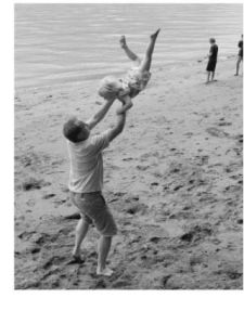 FLYING HIGH ON THE FOURTH OF JULY: Anneke Talke kicks up her heels with the help of her dad Stefan Talke at Paradise Cove. The Talkes have recently moved to Vashon Cohousing and participated in the annual Fourth of July beach party that Jean Bosch