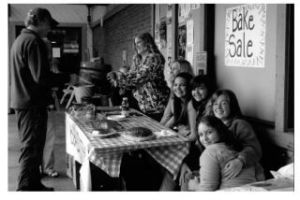 GOOD FOOD FOR A GOOD CAUSE: Visitors from Yosemite stop to buy treats from a bake sale outside Thriftway last Thursday. The sale was the work of these eighth-grade students (with a little help from their parents) to offset some of the expense recent vandalism brought to  the Vashon Island School District. The girls raised $493 in five hours.