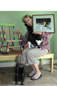 Auction art procurer Terry Fletcher and Crombie show off three items to be auctioned off: a rocking chair by Kristen Reitz-Green