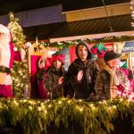 Children stand and wave from a float with Santa during Saturday&rsquo;s Winterfest parade. (Kent Phelan Photo)