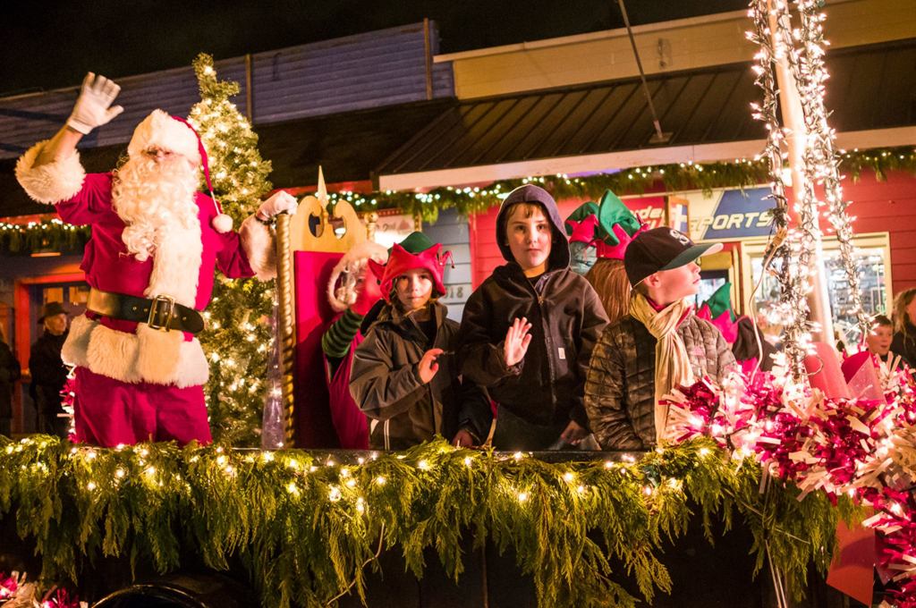 Children stand and wave from a float with Santa during Saturday&rsquo;s Winterfest parade. (Kent Phelan Photo)
