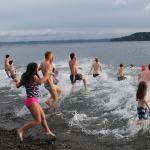 Plungers run into the water yelling and cheering on Sunday afternoon. (Anneli Fogt/Staff Photo)