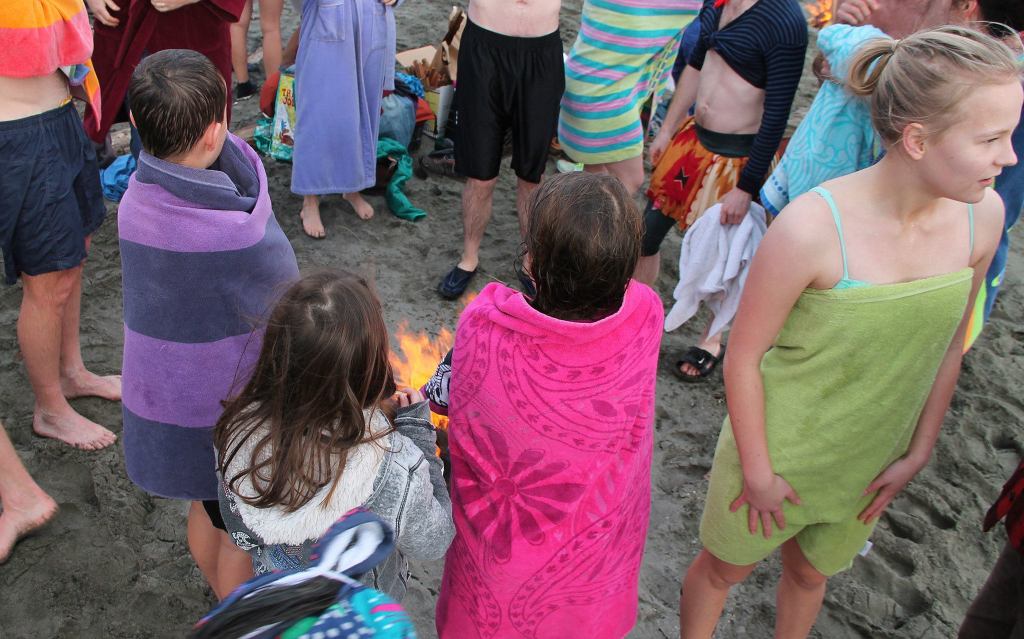 Children gather around one of two fires built to thaw out participants after the plunge. (Anneli Fogt/Staff Photo)
