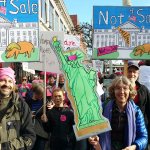 Islanders Denny Levin (left, in green), Marcie Rubardt (right, in blue) and Charlie Pietirick (behind, in UW baseball cap) march in the Seattle women&rsquo;s march on Saturday. They were three of an estimated 175,000 that showed up to march against Trump by uniting for women, the LGBT community, immigration and the environment. (Susan Riemer/Staff Photo)